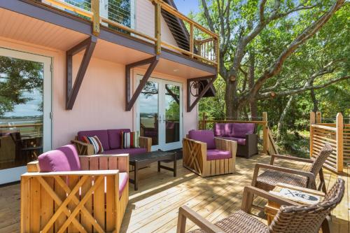 富丽海滩Folly Vacation Vintage Cottage with Stunning Views 218的房屋内带紫色家具的甲板