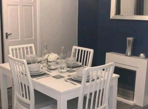唐克斯特Fieldside View, Contractors and Families的白色的餐桌,配有三把椅子和一张白色的桌子及椅子