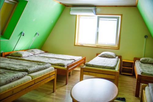 Tiidu基维马度假屋的客房设有两张床、一张桌子和一扇窗户。