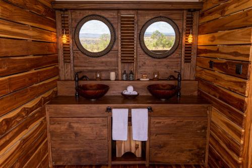 塞伦盖蒂Aurari Camp的一间带两个盥洗盆和两个窗户的浴室
