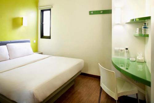 雅加达旁里玛博里1号阿玛里斯酒店的配有一张床和一张书桌的酒店客房