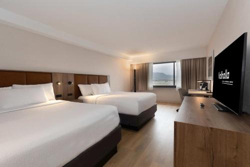 桑德贝Valhalla Hotel & Conference Centre的酒店客房设有两张床和一台平面电视。