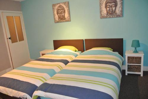 弗朗科尔尚拉多彦度假屋的卧室配有两张床,墙上挂有两张照片
