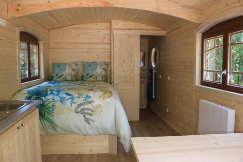 泰昂维Les roulottes a Sandie的小木屋内的卧室,配有床