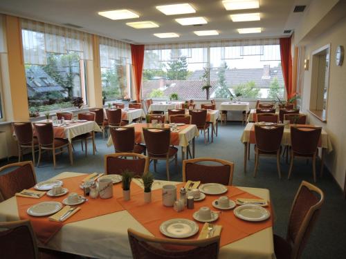 塞海姆-尤根海姆马辰加尼酒店的用餐室设有桌椅和窗户。
