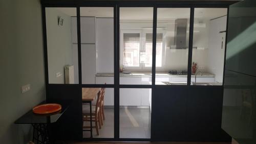 布尔戈斯Apartamento Vadillos - VuT 09-401的厨房配有白色橱柜和带凳子的桌子