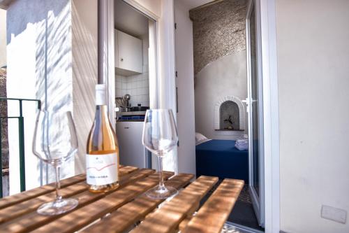 维耶特里B&B Casa Martino SEA VIEW的桌子上放有一瓶葡萄酒和两杯酒