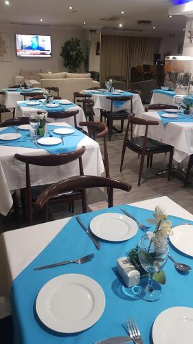 约翰内斯堡Garden Top Hotel的一间配备有蓝白色桌椅的用餐室