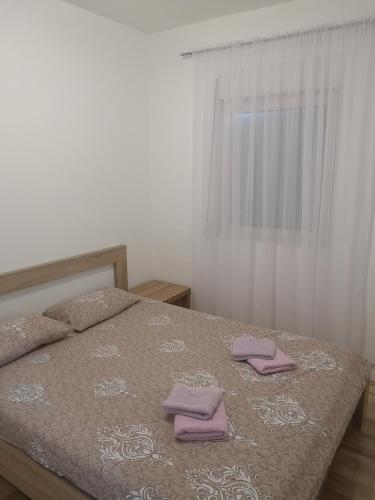 波德戈里察Jednosoban stan Zoja的一间卧室配有一张床,上面有两条毛巾