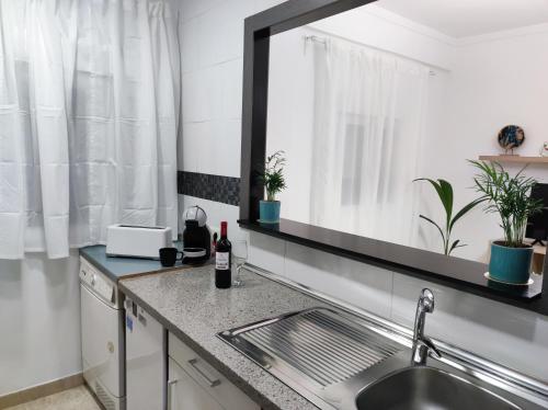 马拉加La Brisa apartamento的厨房柜台设有水槽和镜子