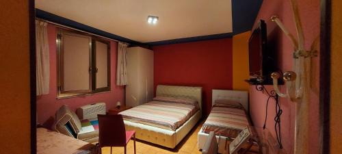 米内尔维诺迪莱切拉弗酒店B的小房间设有床铺和电视