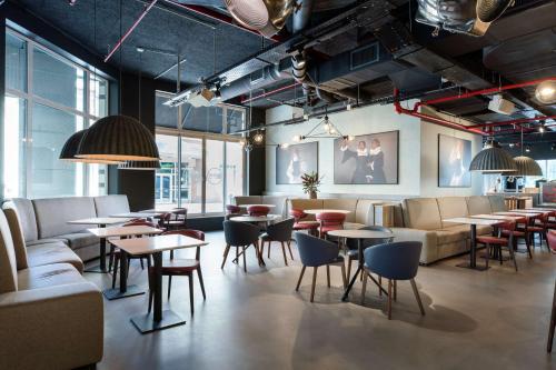 布鲁塞尔Radisson RED Brussels的餐厅设有桌椅和沙发。
