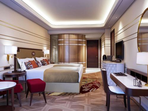马尼拉Admiral Hotel Manila - MGallery的配有一张床和一张书桌的酒店客房