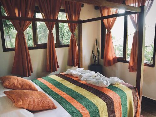 La LagunaCasa Única - Room with breakfast or Cabins with kitchen的一间卧室配有一张带条纹毯子的床和窗户。