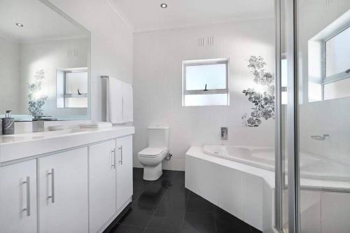 开普敦Prestigious Guest Villa的白色的浴室设有卫生间和水槽。