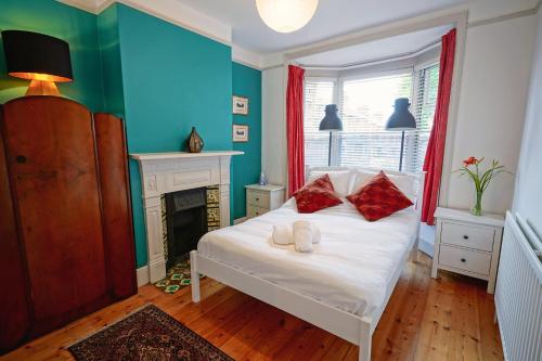 温彻斯特Boscobel Apartments Down的卧室配有带红色枕头的白色床和壁炉
