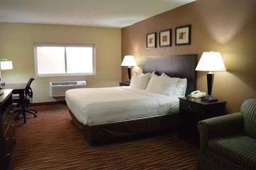 格林里弗First Choice Inn at the Swell的酒店客房设有一张大床和一张书桌。