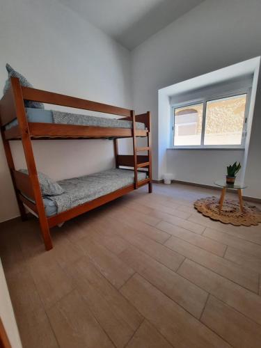 波尔蒂芒Blue Sardine Hostel的客房设有两张双层床和一扇窗户。