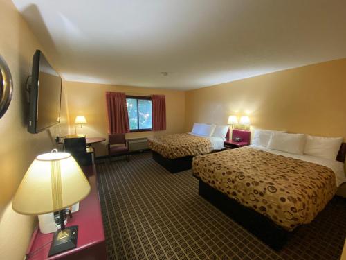 StewartvilleAmerica's Stay Inn Stewartville的酒店客房设有两张床和电视。
