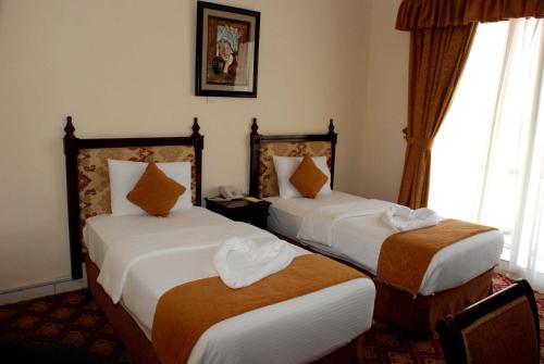 海塞卜迪万阿尔阿米尔酒店的酒店客房设有两张床和窗户。