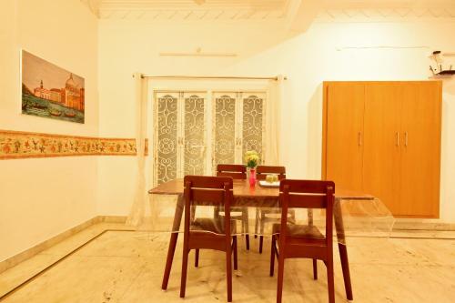 蓬蒂切里BHARATHI RESIDHOME的一间带木桌和椅子的用餐室