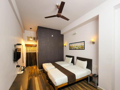 SeonīShivani Palace Hotel, Restaurant & Party Hall的一间卧室配有一张床和吊扇