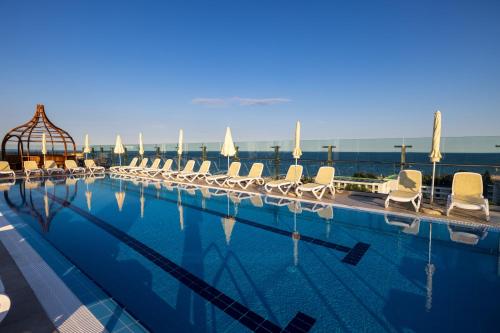 阿尔贝纳MARITIM Hotel Amelia - Luxury Ultra All Inclusive的一个带白色椅子和水的大型游泳池