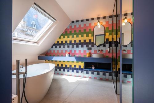 安特卫普P6 Antwerp的带浴缸的浴室和色彩缤纷的瓷砖墙
