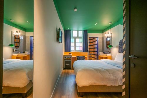 安特卫普P6 Antwerp的一间卧室设有两张床和绿色的天花板