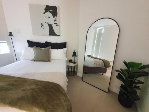 墨尔本达克兰海港避静公寓的一间卧室配有一张床和镜子