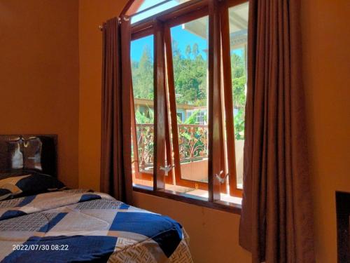 庞越Hotel Nur Cahaya - Syariah的一间卧室设有一张床和一个大窗户