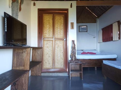 布桑加OcamOcam Azur Inn的一间设有门、床和电视的房间