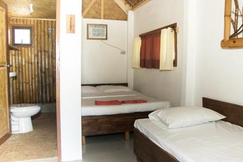布桑加OcamOcam Azur Inn的一间带两张床的卧室和一间带卫生间的浴室