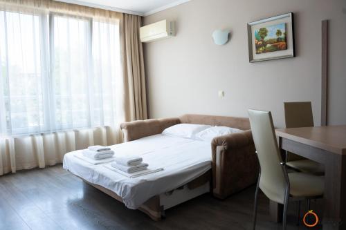 索佐波尔奥林奇别墅公寓式酒店的酒店客房配有一张床铺、一张桌子和一张书桌。