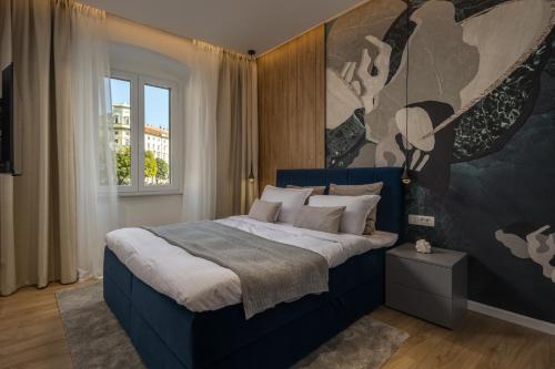 里耶卡Bella Vita Apartments的卧室配有一张蓝色的床,墙上挂着一幅画