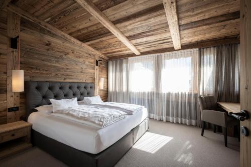 奥蒂塞伊Residence Cesa Sassela的一间卧室设有一张带木制天花板的大床