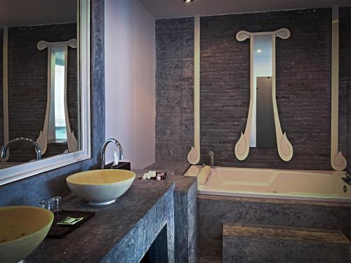拉迈Sand Sea Beach Resort的浴室配有两个盥洗盆和浴缸。