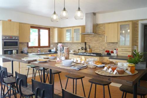 Saint-Jean-de-ThuracLa Maison des Eaux的厨房配有带食物的大木桌