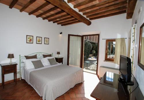 锡耶纳拉雅乡村假期酒店的一间卧室配有一张床、一台电视和一个庭院。