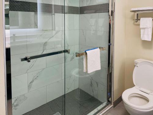 查尔斯湖Quality Inn & Suites Lake Charles的浴室设有玻璃淋浴间和卫生间