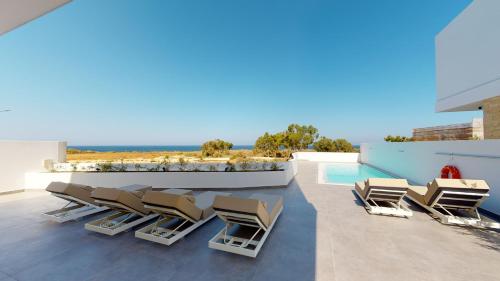 普罗塔拉斯Periyiali Konnos Villas Beach Resort的一个带躺椅的庭院和一个游泳池