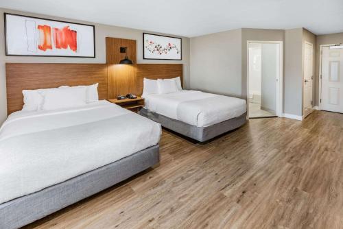 阿德莫尔Hawthorn Extended Stay by Wyndham Ardmore的配有2张床的酒店客房,铺有木地板