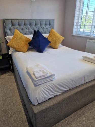 KentLinx View 4 Bedroom House的一张黄色和蓝色枕头的床