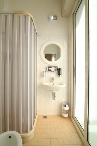 里米尼Hotel Soave的一间带水槽和镜子的浴室
