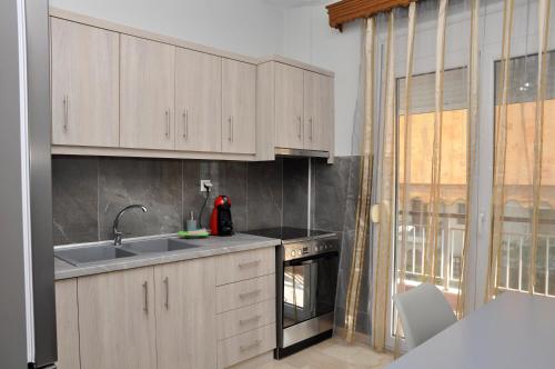 埃泽萨Friendly Flat 3的厨房配有白色橱柜、水槽和烤箱。