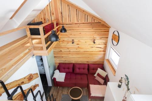 布莱德Lavender Lodge Bled的阁楼间设有红色的沙发和梯子
