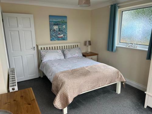 多佛尔Castle View Dover的一间卧室配有一张床、一张桌子和一个窗户。