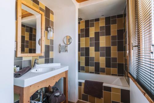 谷雪维尔La Maison Les Peupliers的一间带水槽、浴缸和镜子的浴室