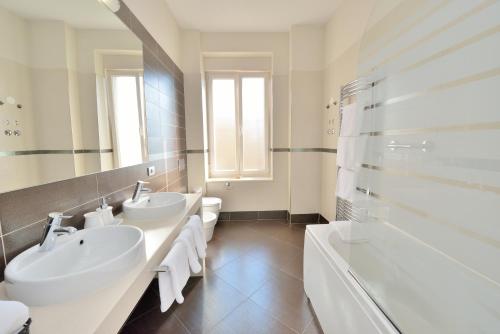 扎达尔Eden Penthouse Apartments的白色的浴室设有2个盥洗盆和1个浴缸。