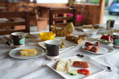 瓦勒博内Guesthouse Skender Selimaj的一张桌子,上面放着盘子和杯子